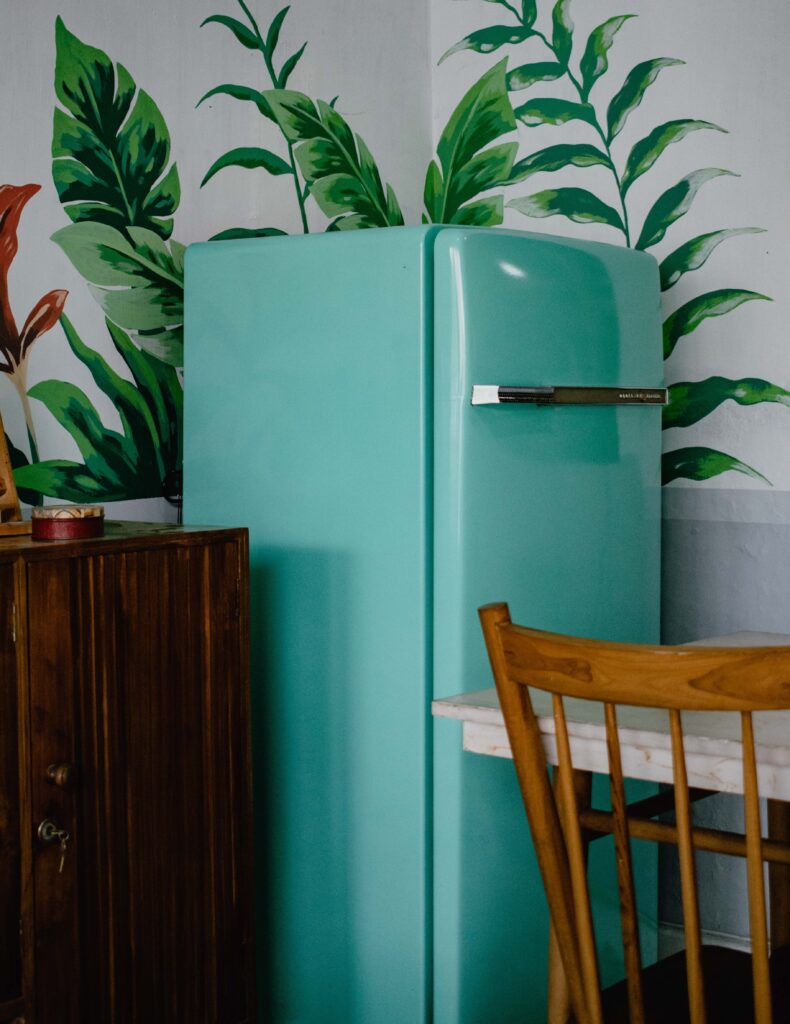 green refrigerator in the corner of a kitchen
